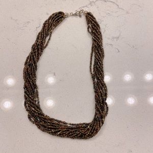 LOTS OF TINY BEADS ON TWISTED NECKLACE.